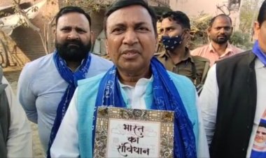 हाथों में संविधान की किताब लेकर लोगों के डोर टू डोर वोट मांग रहा प्रत्याशी...